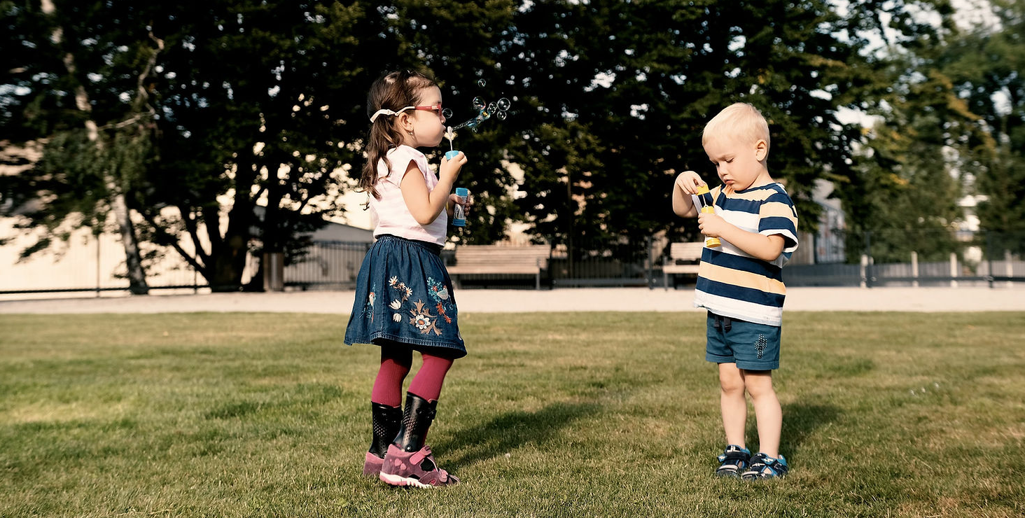 two children playing with bubbles. One child wearing piro, afo brace.