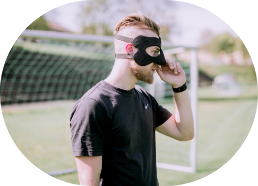 man wearing a raptor mask on a football field