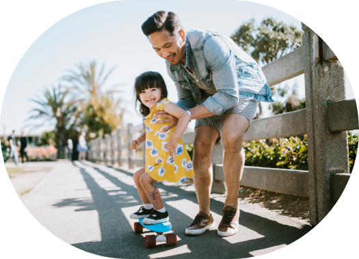 child wearing an afo, piro, on a skateboard with father supporting